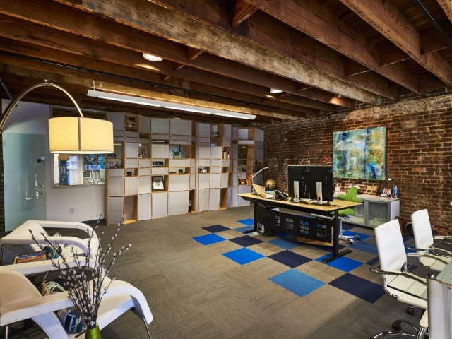Photo of office defined by Kinetic's signature shelves and a portion of the floor featuring a carpeted section of alternating tiles of Kinetic's colors.
