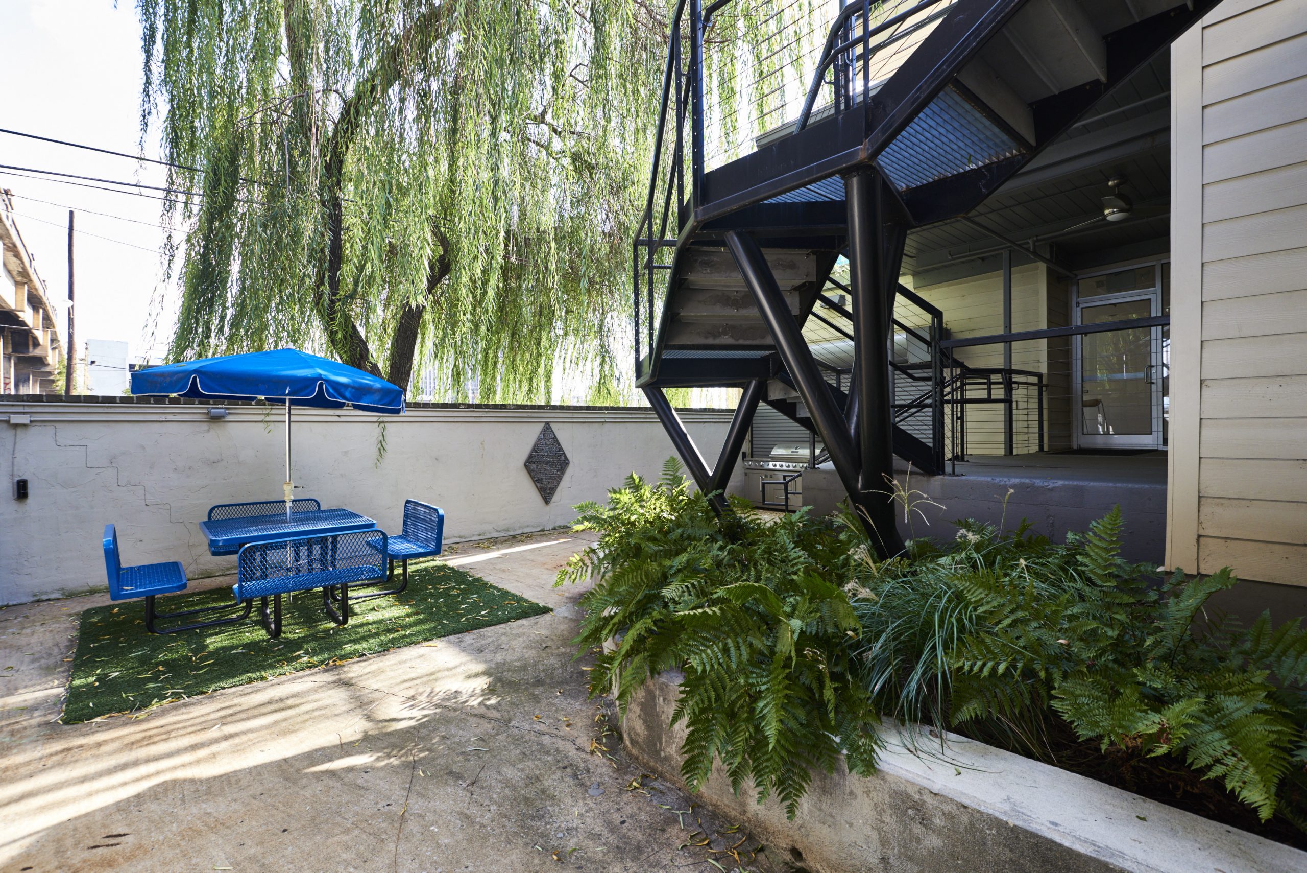 Photo of Kinetic's outdoor dining area with a table and umbrella.