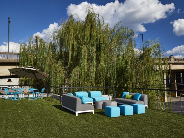 Photo of Kinetic's rooftop couches, umbrellas, tables, and chairs.
